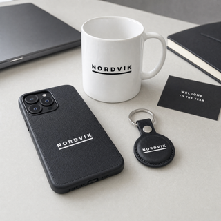 Corporate welcome pack: branded AirTag holder, phone case and mug with company logo
