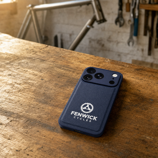 Navy blue vegan leather iPhone case with company logo on a workshop bench
