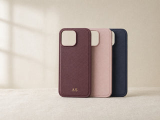 Three personalised vegan leather iPhone cases in burgundy, pink and navy with gold embossed initials
