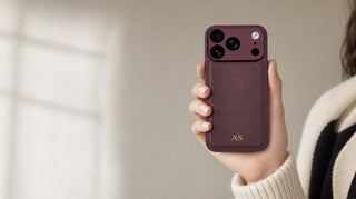 Woman holding iPhone with burgundy personalised leather case, gold embossed initials