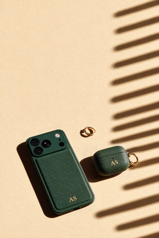 Matching green vegan leather iPhone and AirPods cases with gold initials