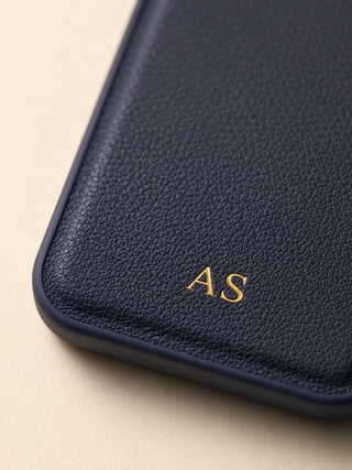 Close-up of navy vegan leather case with gold embossed initials AS